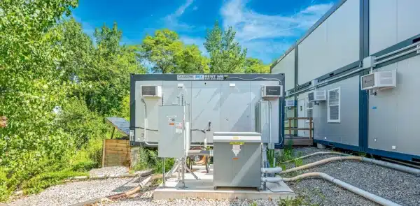 Modular building HVAC units in an outdoor setting with blue skies and green trees