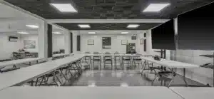 Modern conference room with U-shaped table setup and large screens on walls