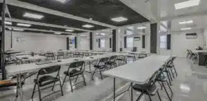 Spacious modern classroom with folding chairs and tables arranged for a meeting or training session.