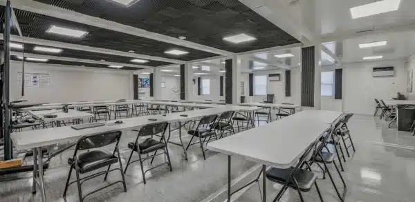 Spacious modern classroom with folding chairs and tables arranged for a meeting or training session.