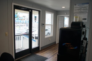 Inside a car dealership showroom with glass doors and a coffee machine