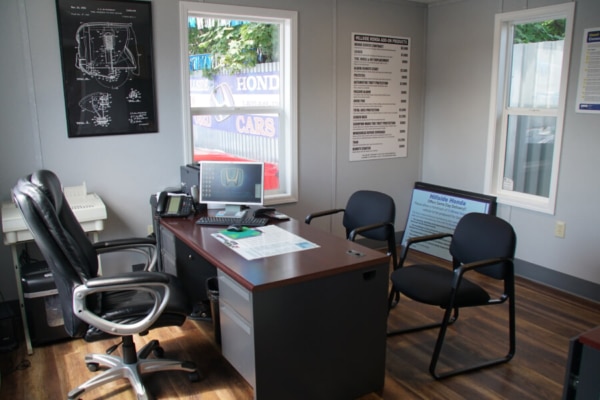 Auto repair shop office with desk two chairs and a computer on wooden floor